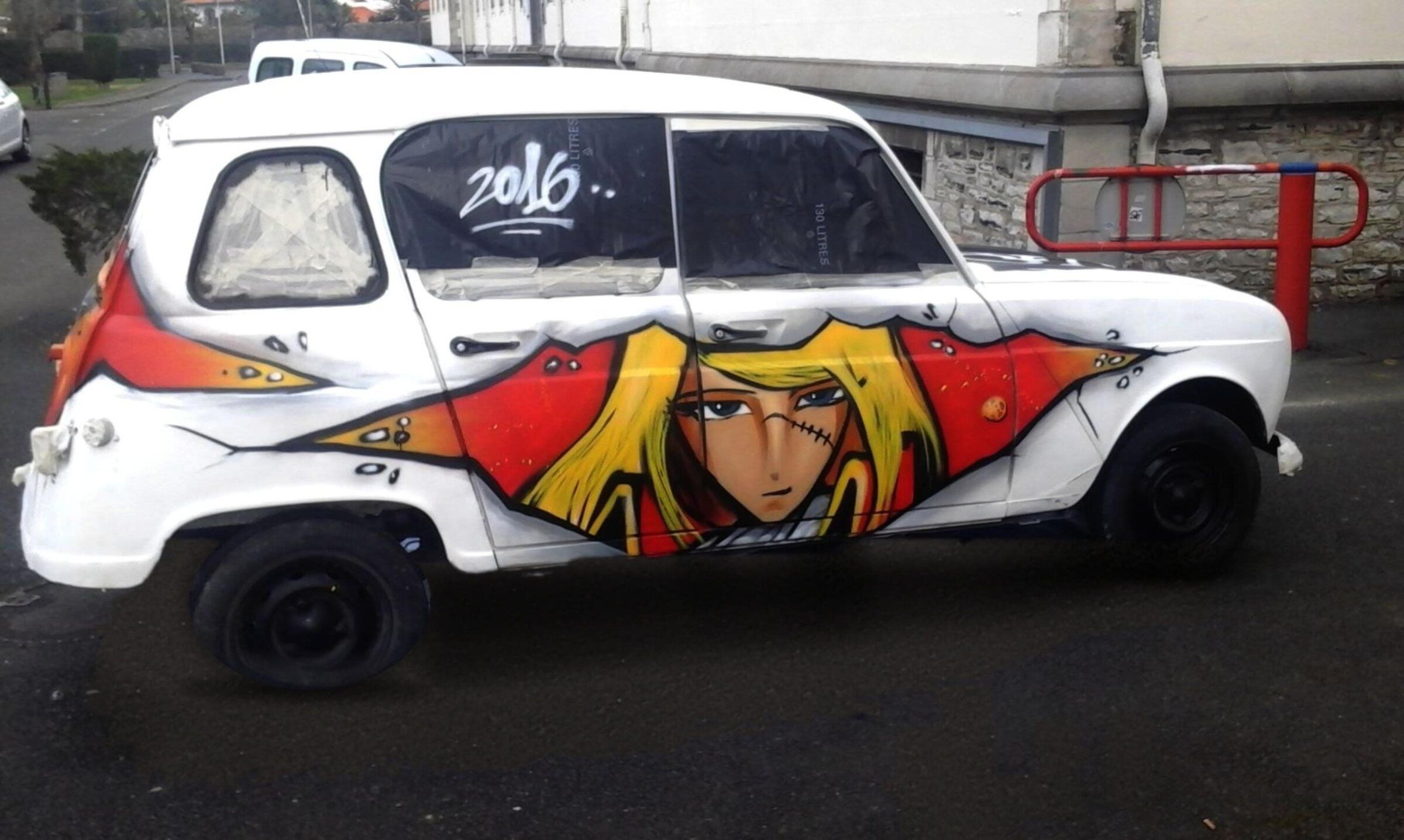 Voiture blanche peinte d'un portrait d'Albator sur la portière