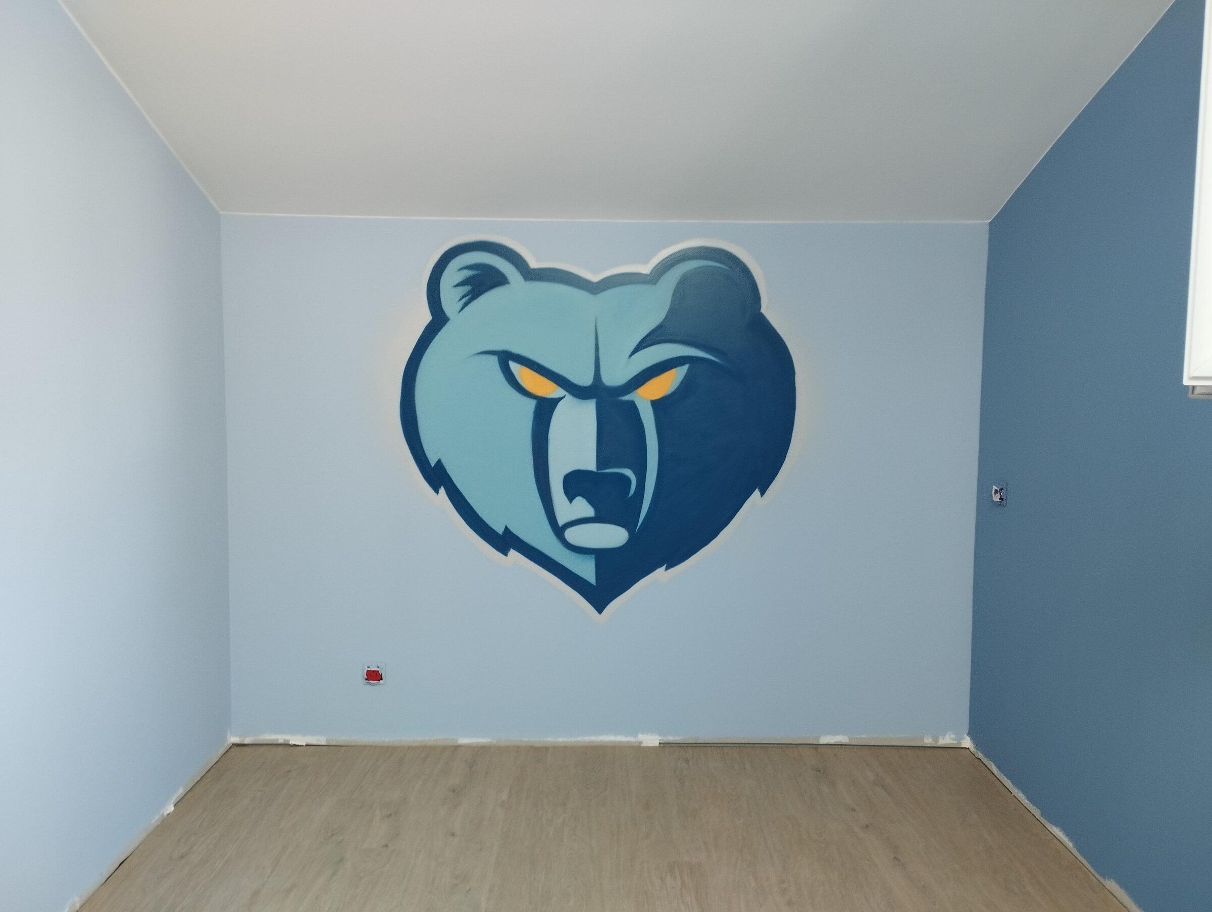 Tête d'ours bleue peinte au mur d'une chambre d'enfant