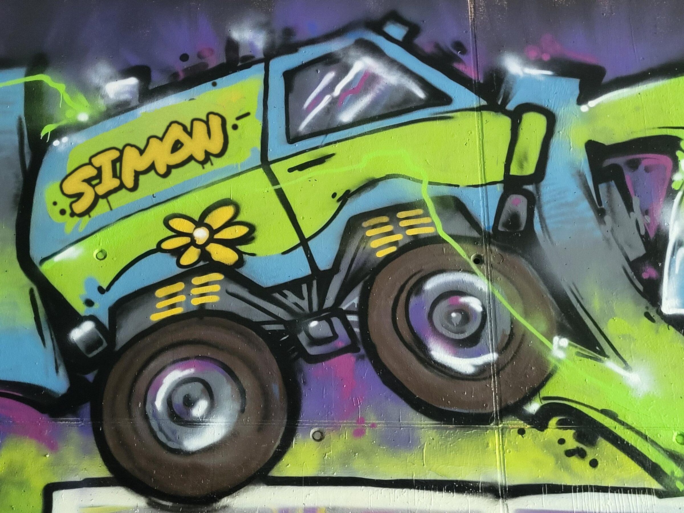 La Mystery Machine transformée en monster truck, sur fond vert fluo